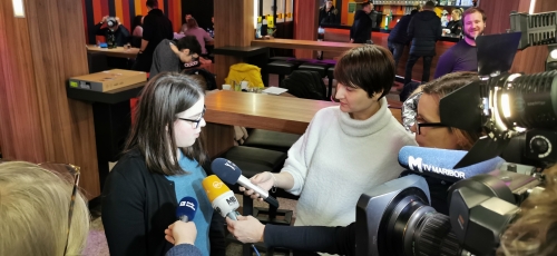 Študentka odgovarja na vprašanja novinarjev