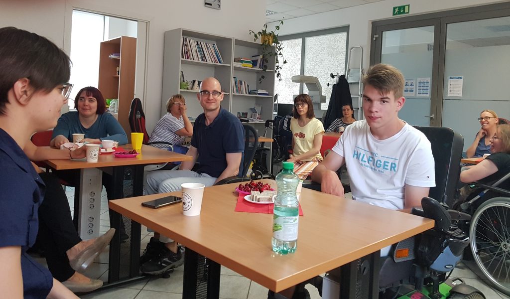 Člani ob mizah jedo slano in sladko pecivo ter češnje