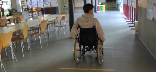 Dijak se pelje po šoli z invalidskih vozičkom