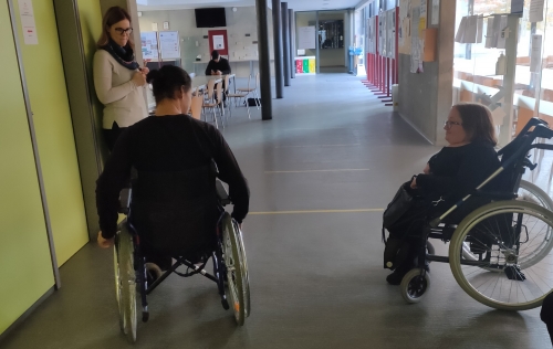 Dijak se po hodniku pelje z invalidskim vozičkom