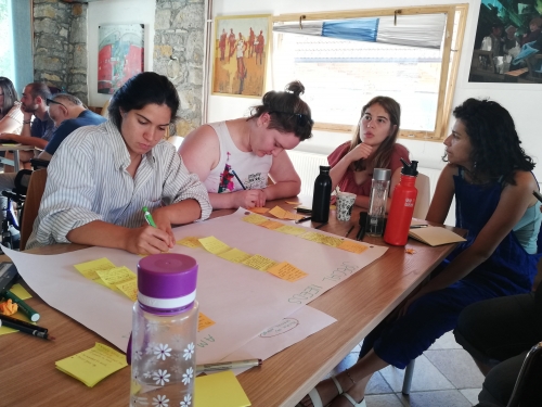 Udeleženci pišejo ideje med seminarjem v Sloveniji