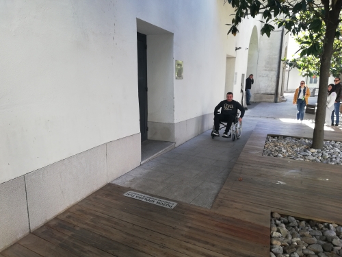 Udeleženec se pelje z invalidskim vozičkom po klančini