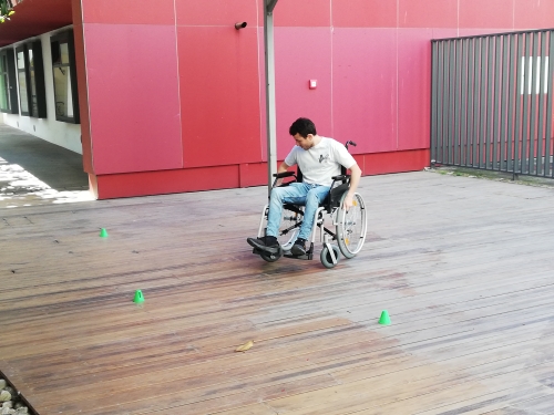 Udeleženec se preizkuša v vožnji z invalidskim vozičkom
