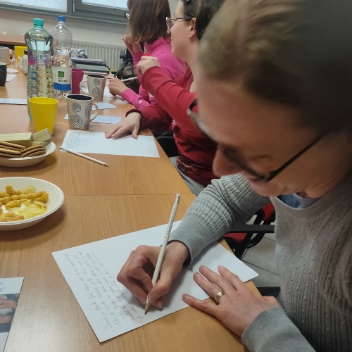 Udeleženka piše z roko