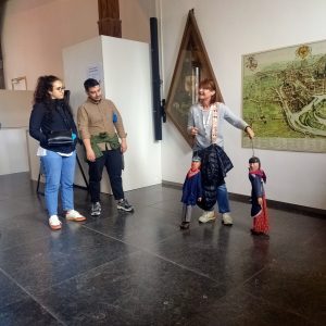 Turistična vodička v Liegu nam kaže lutki, ki predstavljata mesto