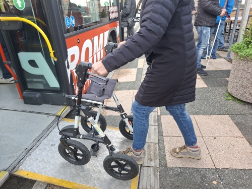Udeženka stopa s hojico po klančini na avtobus