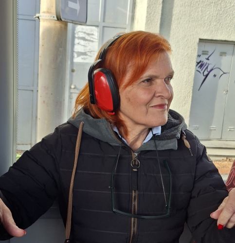 Udeleženka z delavskimi slušalkami, ki zmanjšajo hrup na avtobusu
