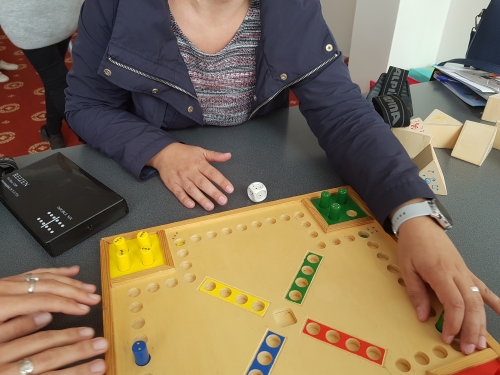 Udeleženka z rokami šteje polja na igrali ploskvi, da bo prestavila figuro na primerno mesto