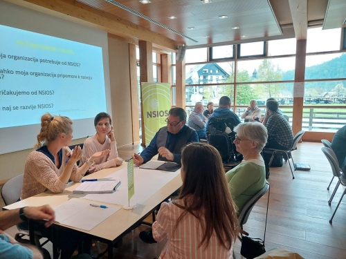 Udeleženci za mizami v skupinah