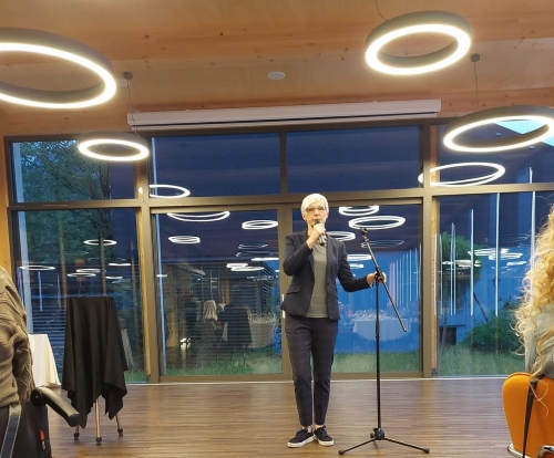 Udeleženka govori v mikrofon