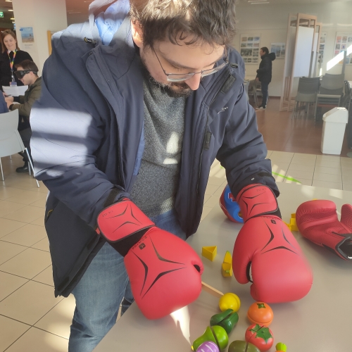 Udeleženec spoznava težave z motoriko rok z opravljanjem naloge z boksarskimi rokavicami