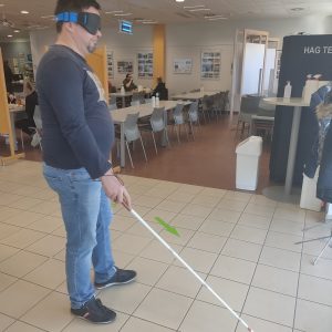 Udeleženec hodi z belo palico
