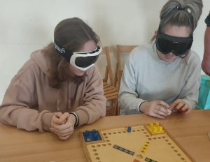 Dijakinji s črnimi očali igrata Človek ne jezi se prilagojen za slepe in slabovidne