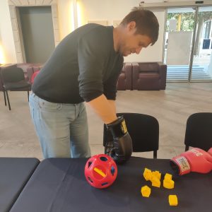 Udeleženec vstavlja like v posebne odprtine in tako spoznava težave z motoriko rok