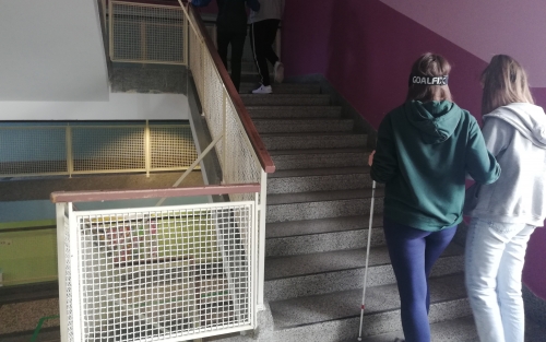 Dijakinja hodi v spremstvu z belo palico po stopnicah dijaškega doma