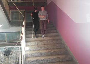 Dijakinja hodi v spremstvu z belo palico po stopnicah