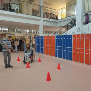 Slalom z invalidskim vozičkom med stožci