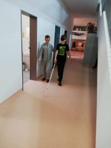 Hoja z belo palico po hodniku šole