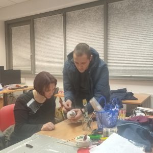Šofer pomaga eni od udeleženk pri snežaku