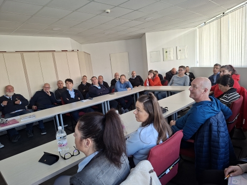 Zaposleni Marproma spremljajo predavanje za mizami postavljenimi v obliki črke U